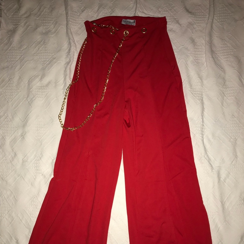 Fashionable red pants with gold chain.